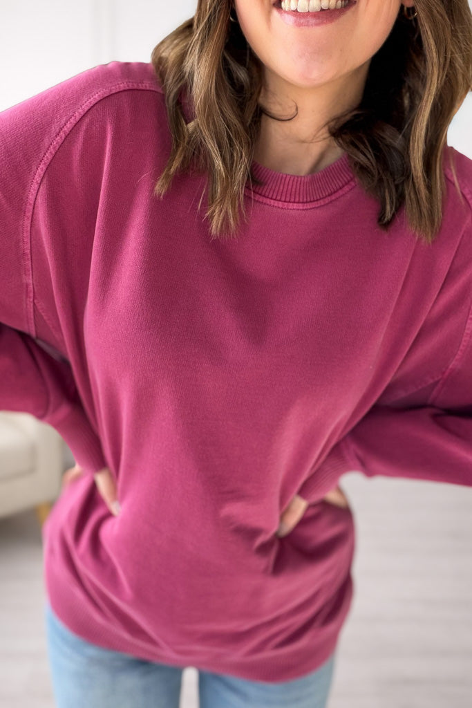 Person wearing a mulberry sweater with a blurred background