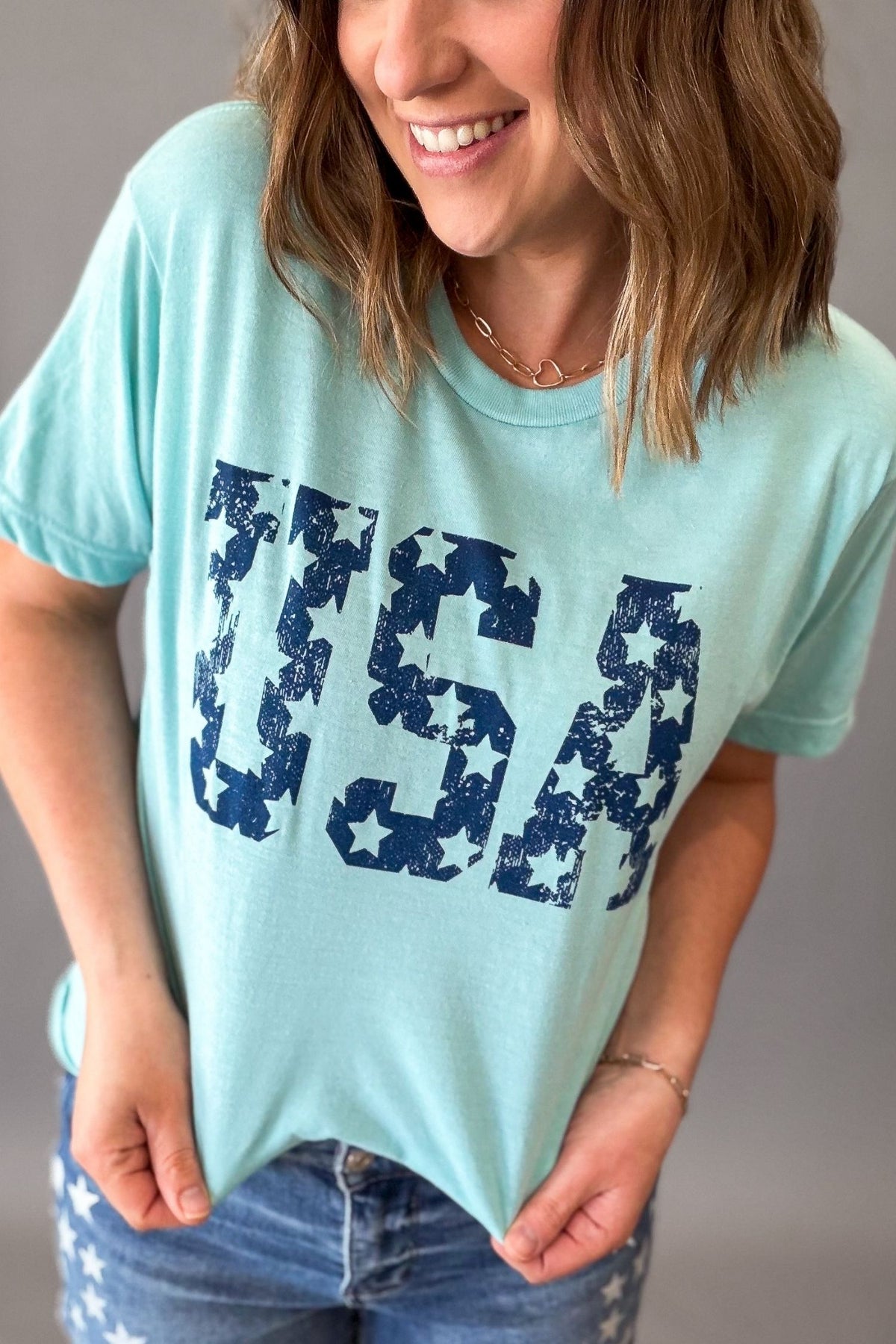 woman wearing a baby blue tee with a navy star USA graphic