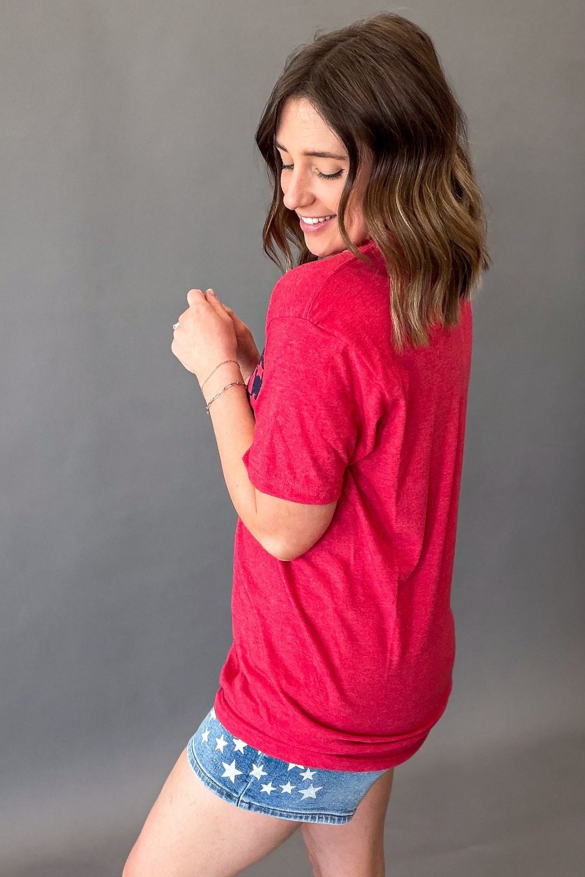 woman wearing a usa graphic tee showing the solid red back details
