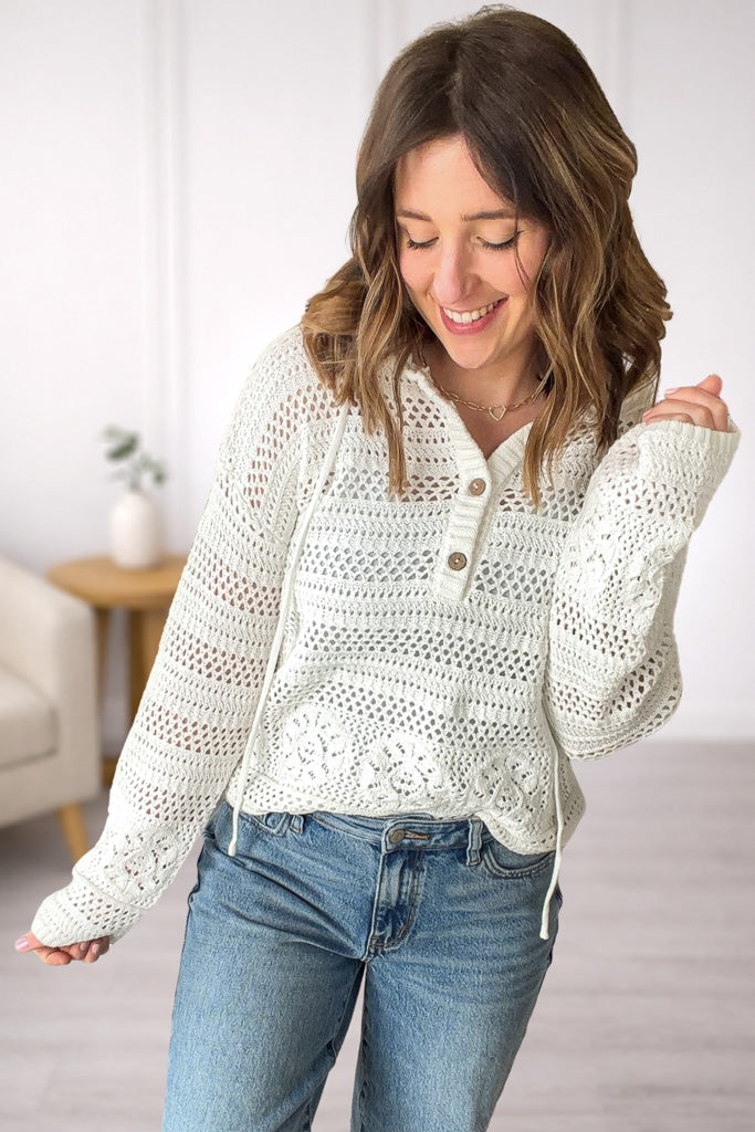 Front view of premium white crochet v-neck hoodie tucket and top button undone with open knit texture and relaxed fit.