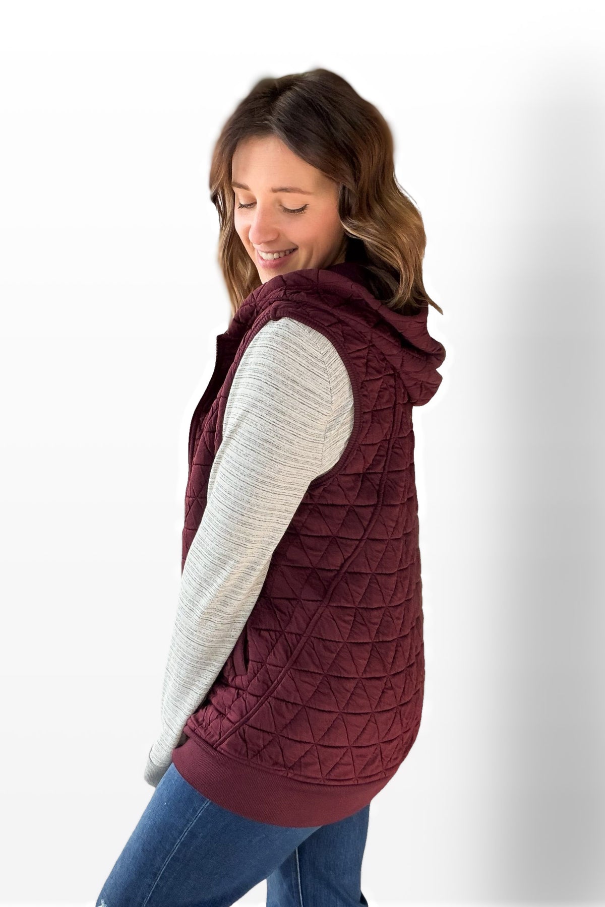 Woman wearing a wine quilted vest on a white background