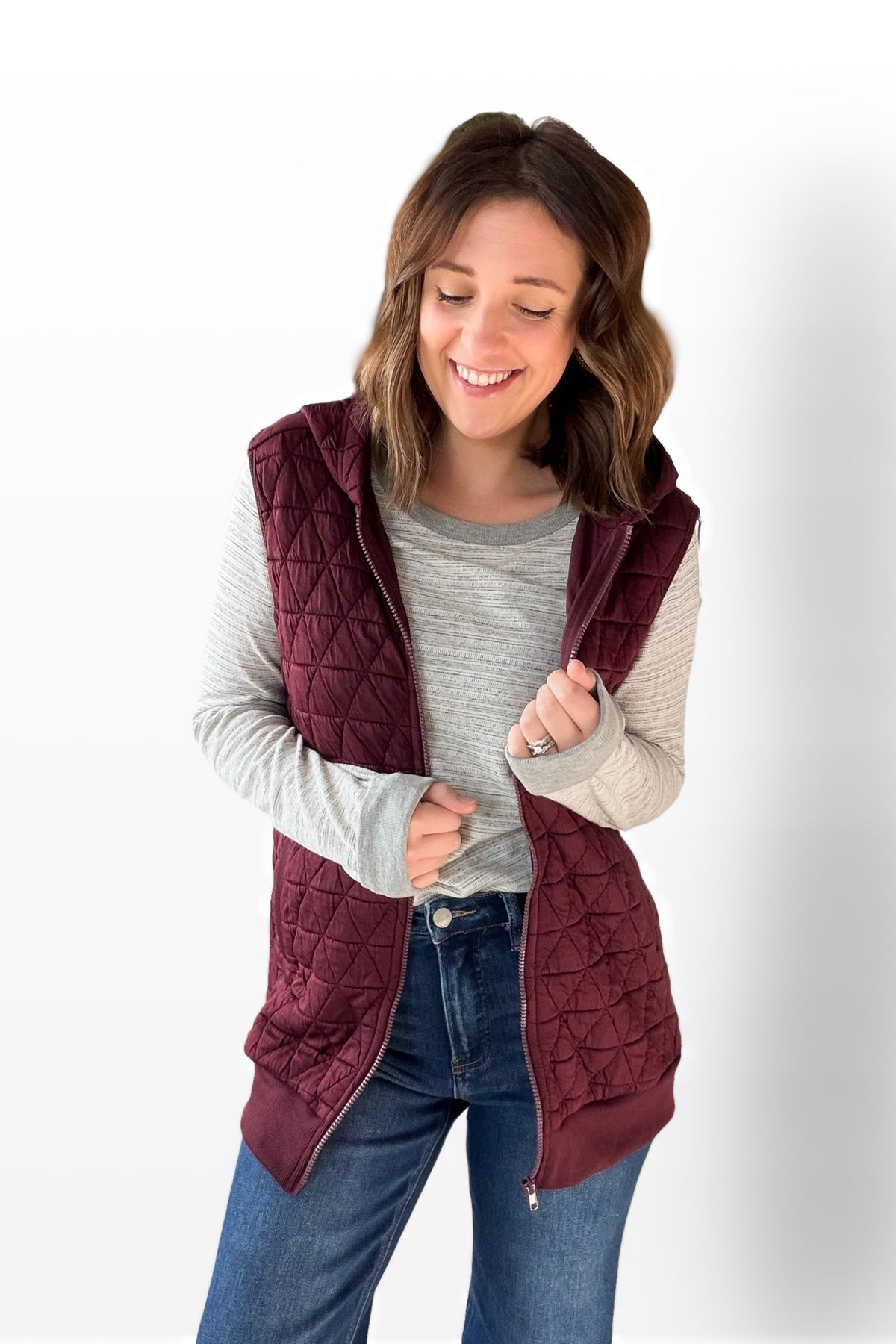 Woman wearing a wine quilted vest on a white background