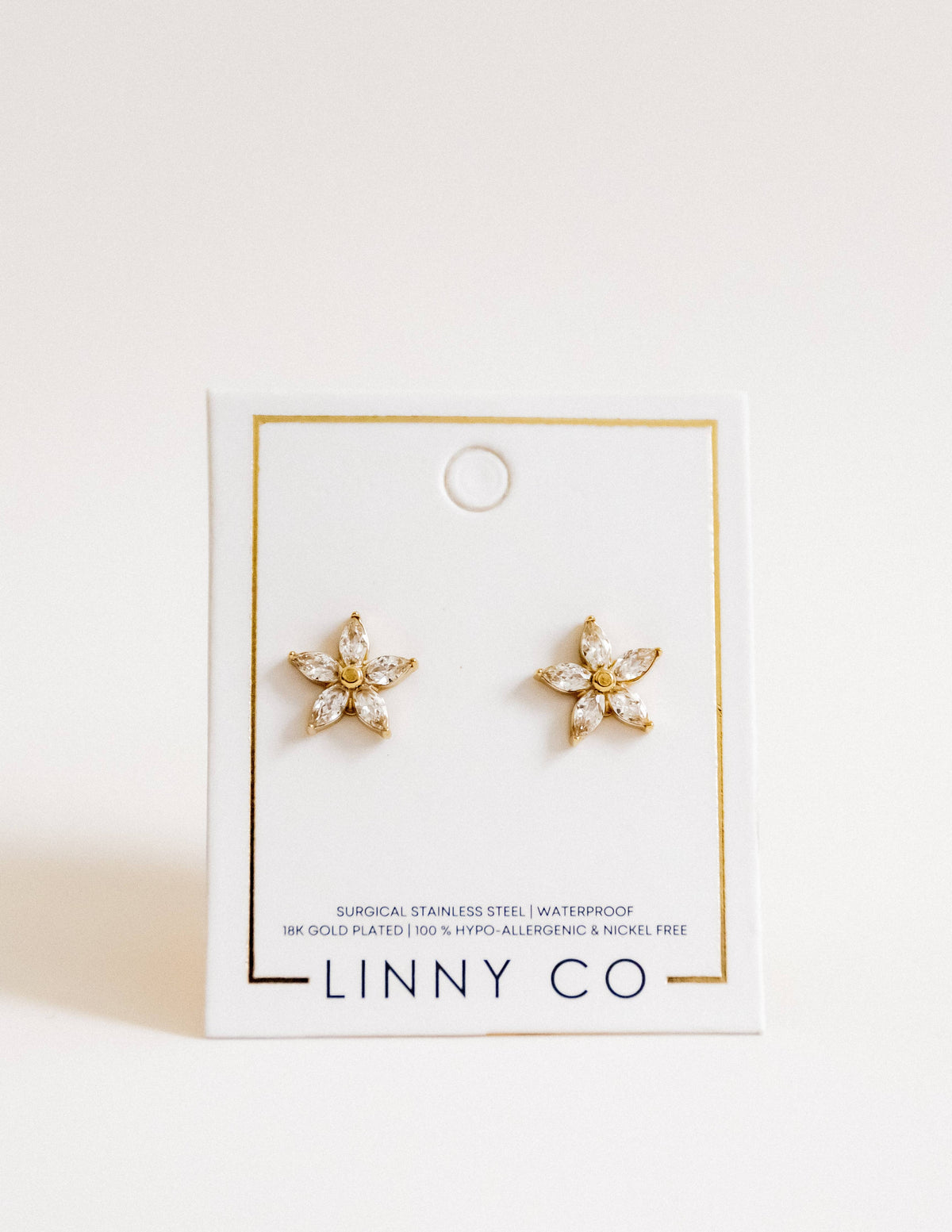 Gold star-shaped earrings on a LINNY CO branded card with a white background
