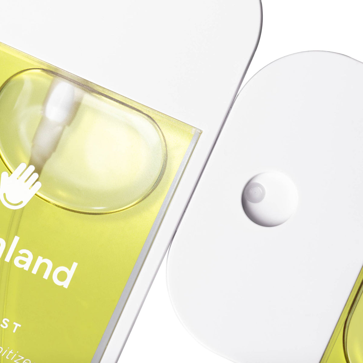 Close-up of a yellow bottle with a white cap, featuring the brand 'land'.